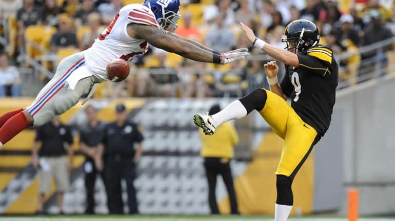 Giants' Damontre Moore, left, blocks a punt by Pittsburgh Steelers...