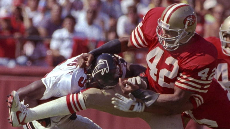 San Francisco 49ers defensive back Ronnie Lott tackles Atlanta Falcons...