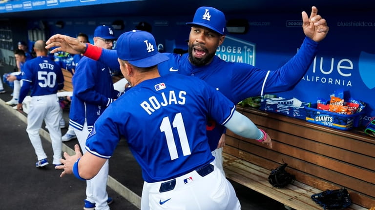 Los Angeles Dodgers shortstop Miguel Rojas (11) greets right fielder...
