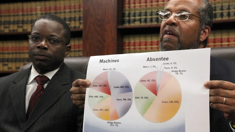 Attorney Fred Brewington, right, with poll watcher Dennis Jones, discusses...