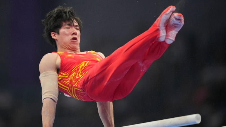 Zhang Boheng of China competes on the parallel bars during...