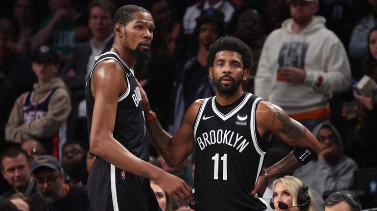 The Nets' Kevin Durant, left, and Kyrie Irving look on in...