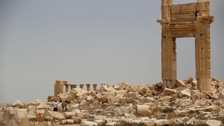 Tourists visit Roman ruins in Palmyra, Syria, Tuesday, May 11,...