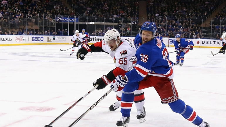 The Rangers' Dominic Moore gets off a shot as he...