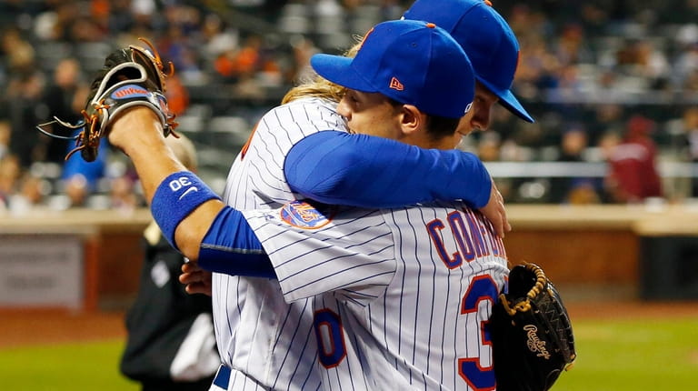 Noah Syndergaard #34 of the New York Mets greets teammate...