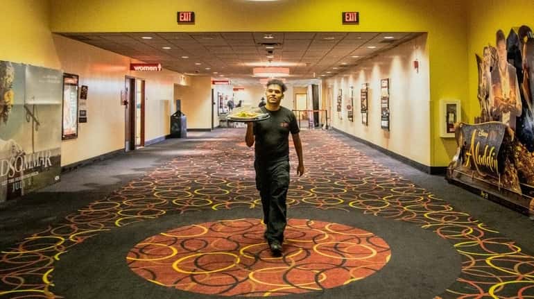 AMC Theatres employee Leo Gomez on his way to deliver a...