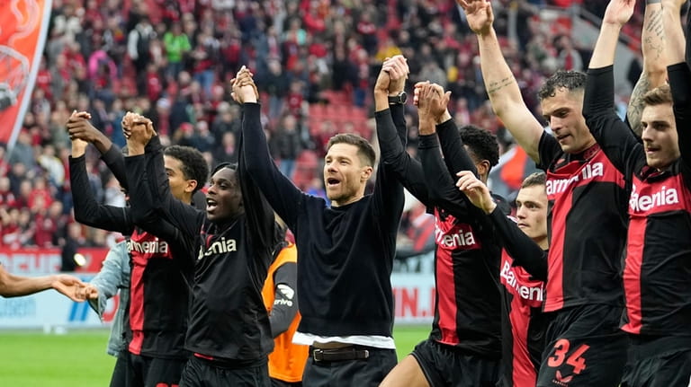 Leverkusen's head coach Xabi Alonso, centre, celebrates with his team...