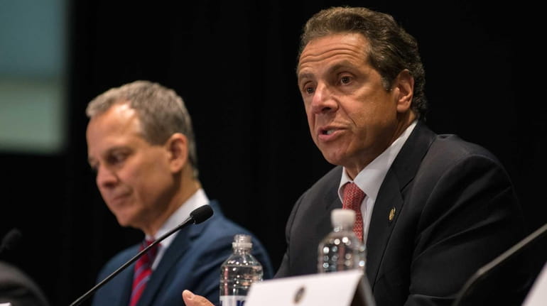 New York Gov. Andrew M. Cuomo, right, issues an executive...