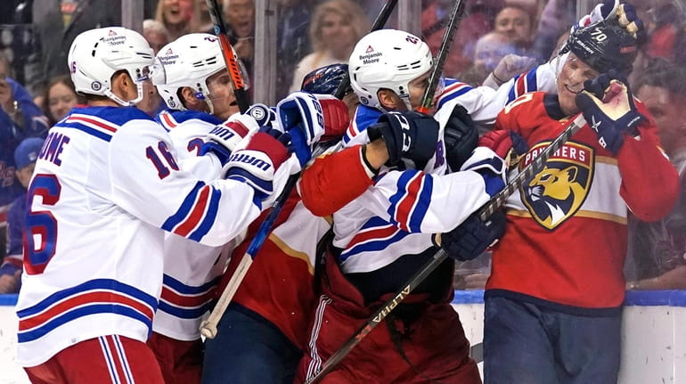 Rangers defenseman Libor Hajek, second from right, grabs Panthers right...