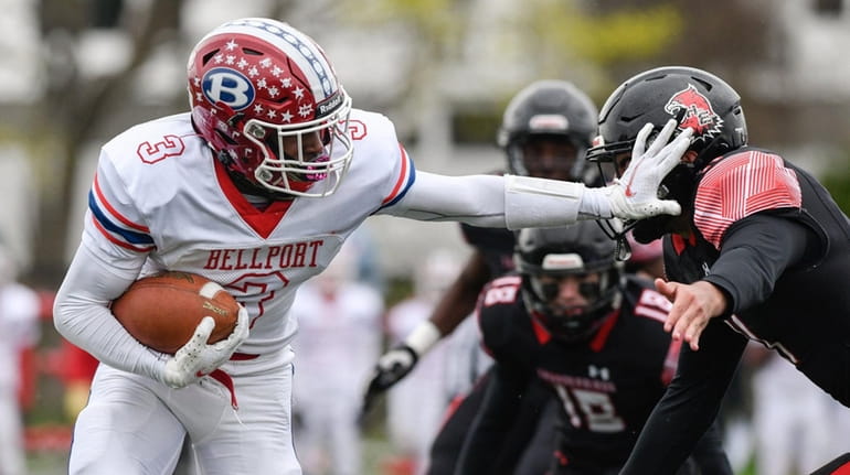 Ka'Shaun Parrish of Bellport holds off the defense during the...