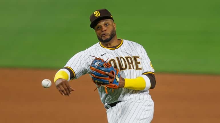 Padres second baseman Robinson Cano makes the throw to first...