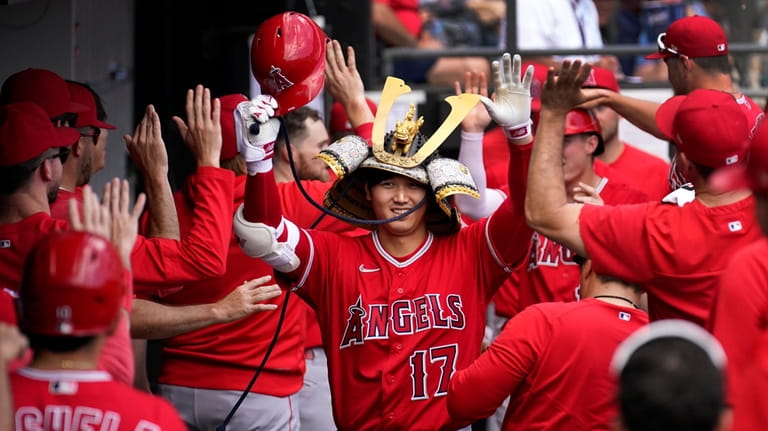 Los Angeles Angels' Shohei Ohtani celebrates in the dugout his...