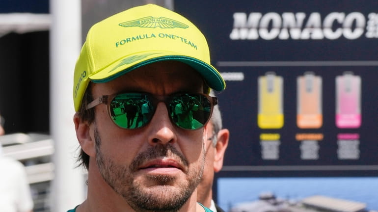 Aston Martin driver Fernando Alonso of Spain walks in the...
