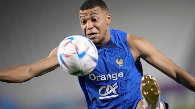 France's Kylian Mbappe controls the ball during a training session...
