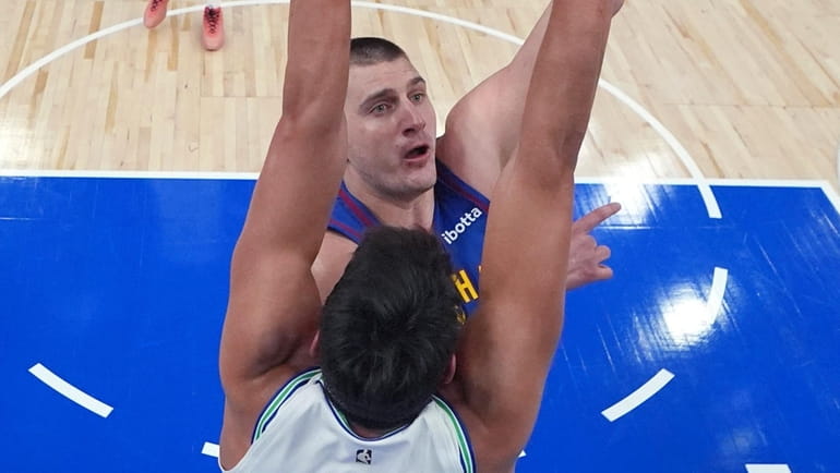 Nuggets center Nikola Jokic shoots over Timberwolves center Luka Garza...
