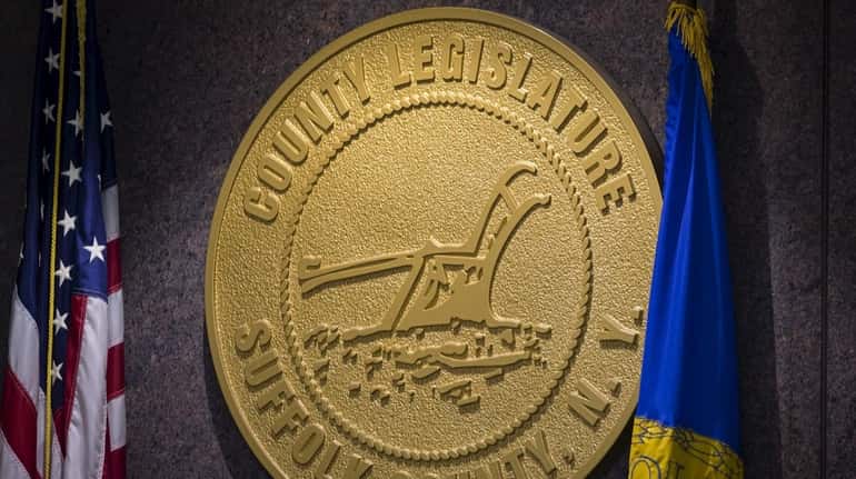 The Suffolk County Legislature medallion hangs on the all at...