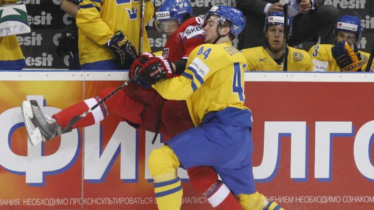Sweden's Tim Erixon, right, fights for the puck with Milan...