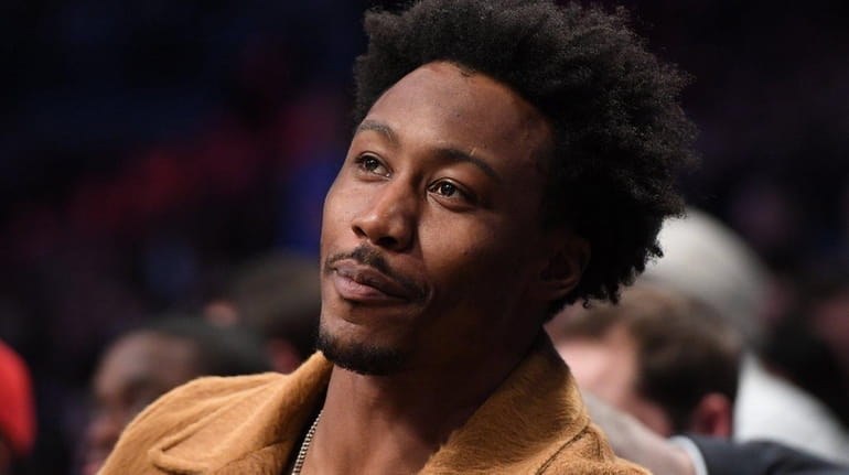 New York Jets wide receiver Brandon Marshall sits courtside for...