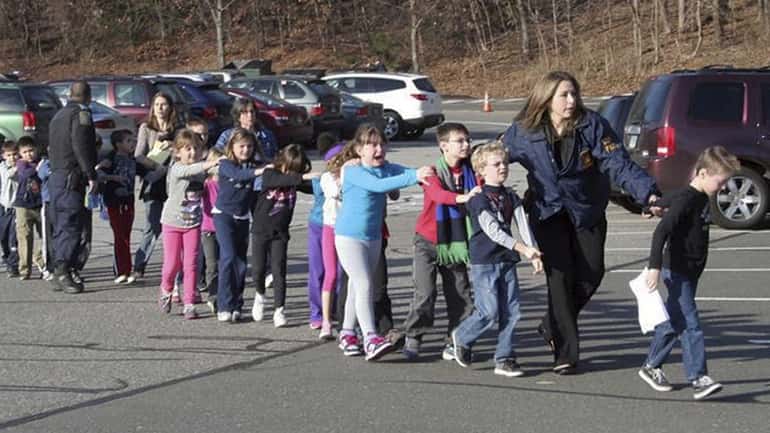 Connecticut State Police lead children from Sandy Hook Elementary School...