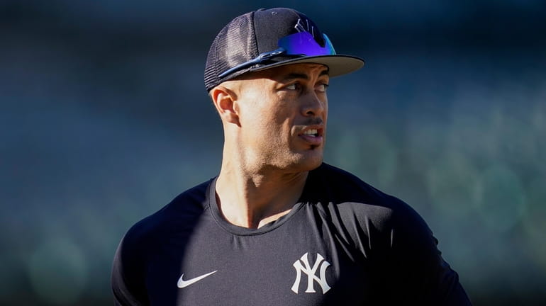 The Yankees' Giancarlo Stanton walks on the field during batting...