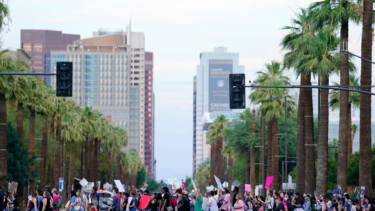 Protesters march near downtown Phoenix after the Supreme Court overturned...