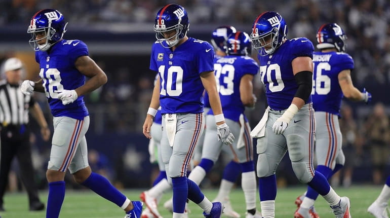 The Giants offense walks off the field during a game...