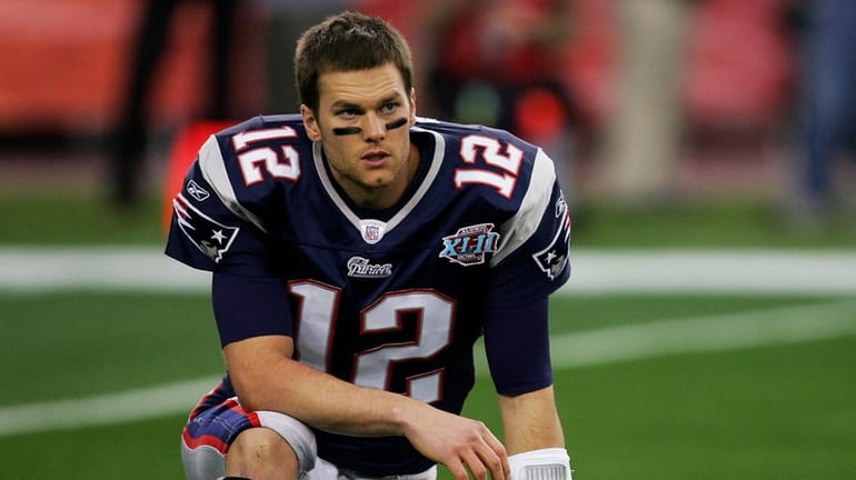 Quarterback Tom Brady #12 of the New England Patriots stretches...