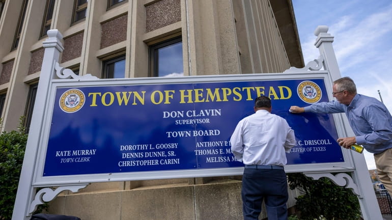 Hempstead Supervisor Don Clavin, right, and Councilman Anthony D'Esposito remove antisemitic graffiti from...