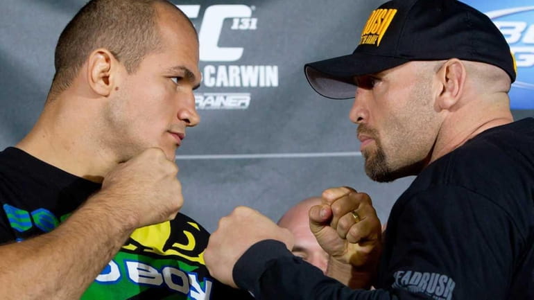 Junior Dos Santos, left, and Shane Carwin face off after...