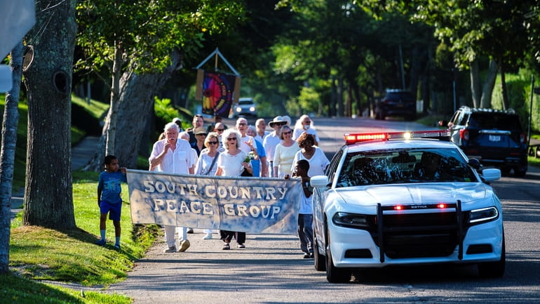 Participants march in silence on Bellport Lane in Bellport on Sunday.