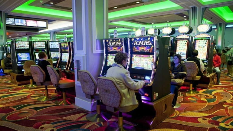 Guests play slot machines at the new Resorts World Casino...