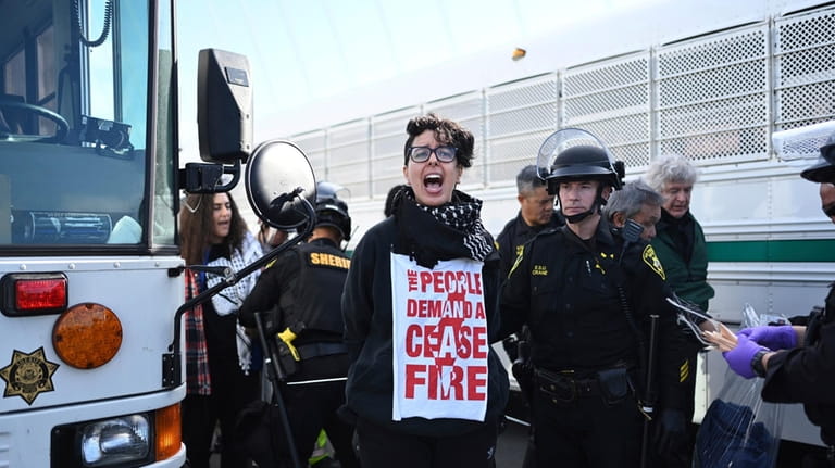 Police officers detain a protester blocking the San Francisco-Oakland Bay...