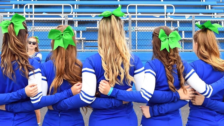 The Port Washington cheerleading squad wears green ribbons to support...