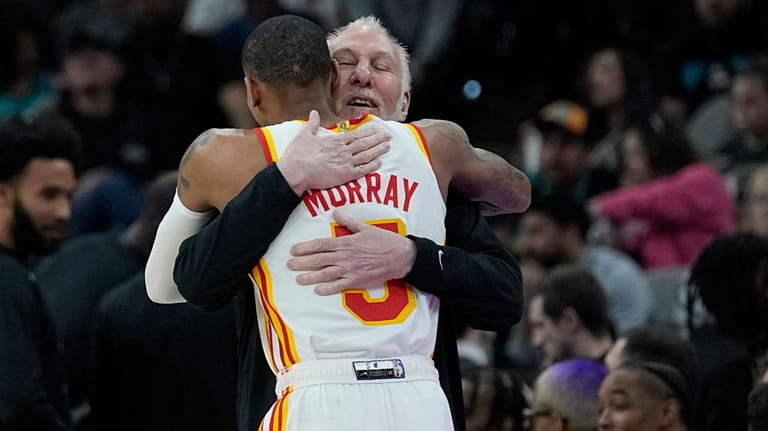 San Antonio Spurs head coach Gregg Popovich, right, hugs Atlanta...