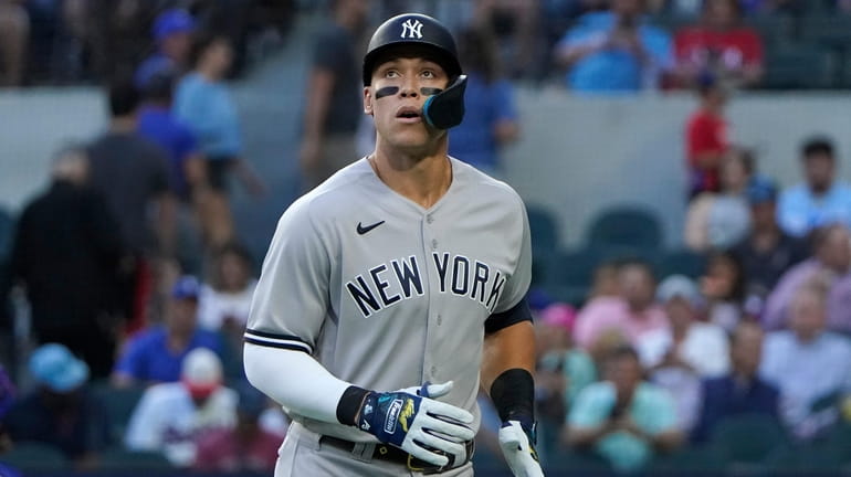 The Yankees' Aaron Judge head to the dugout after a...
