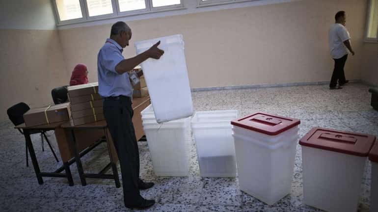 A Libyan election official works at a polling station in...