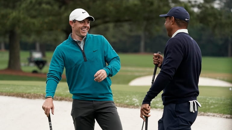 Tiger Woods is greeted by Rory McIlroy, of Northern Ireland...