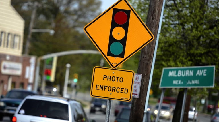 A sign indicating the presence of a red-light camera is...