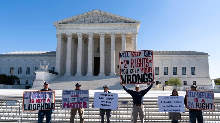 Demonstrators rally outside the U.S. Supreme Court in Washington, Wednesday,...