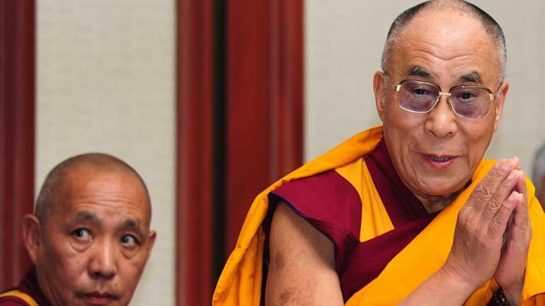 The Dalai Lama greets the media on arrival for a...