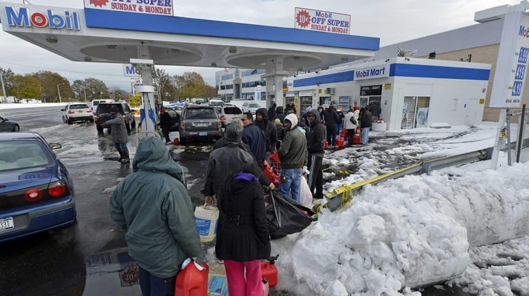 Dozens of people wait in line at the Mobil gas...