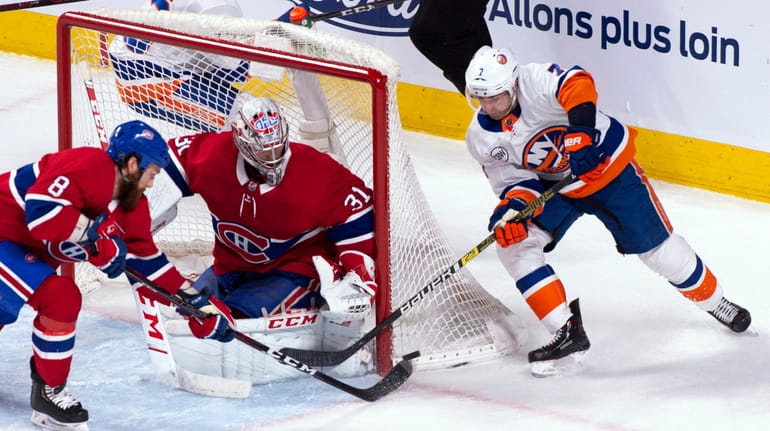Canadiens goaltender Carey Price and defenseman Jordie Benn stop the Islanders'...