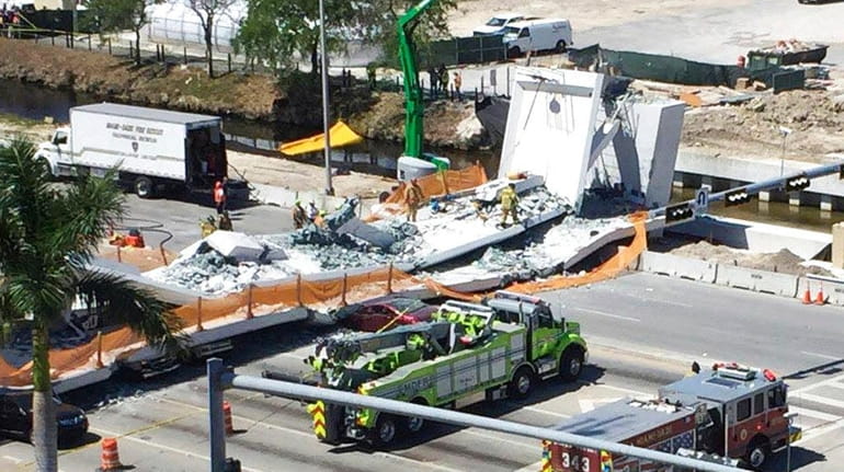 Emergency personnel respond to a collapsed pedestrian bridge at Florida...