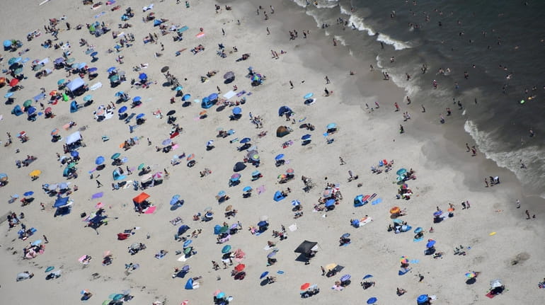 Crowds surge onto the sand at Jones Beach in July. The state...