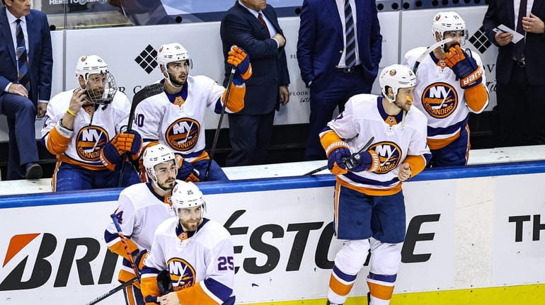 The Islanders react after their 4-3 overtime loss against the...