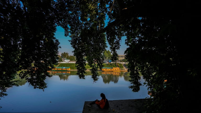 Kashmiri student Aayat hameed sits on the banks of the...