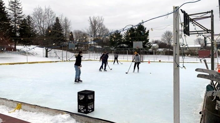 People skate and play hockey on a frozen pond found...