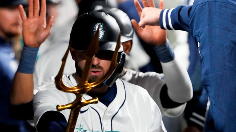 Seattle Mariners' Mitch Haniger points a trident in the dugout...