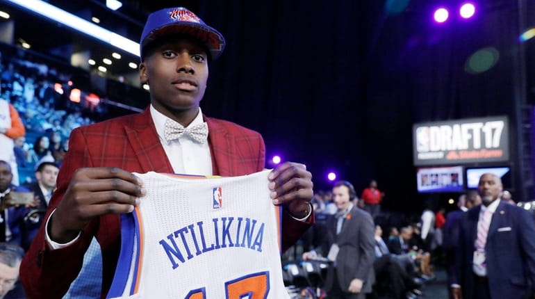 Frank Ntilikina holds up his jersey after being picked No....