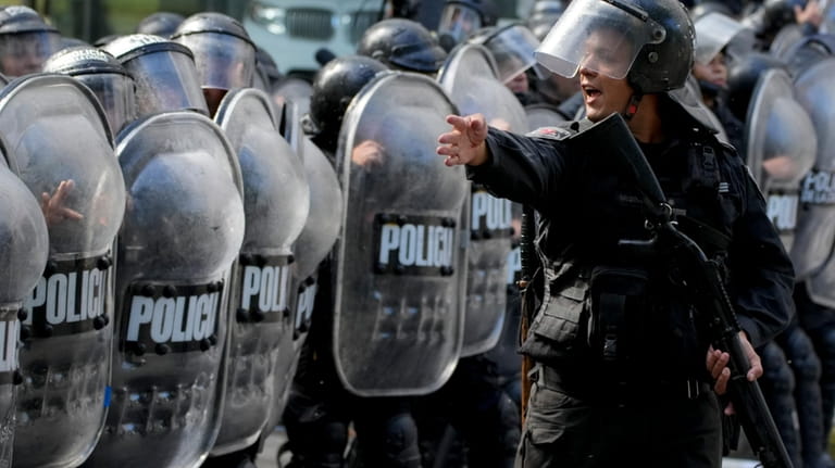 Police organize themselves as they work to disperse an anti-government...